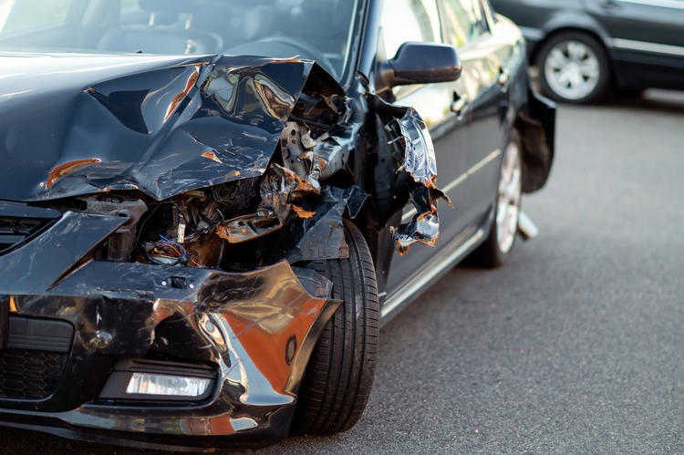 Chicago Car Accident Attorney - Close-up of damaged car part after accident showing broken metal and scratches.