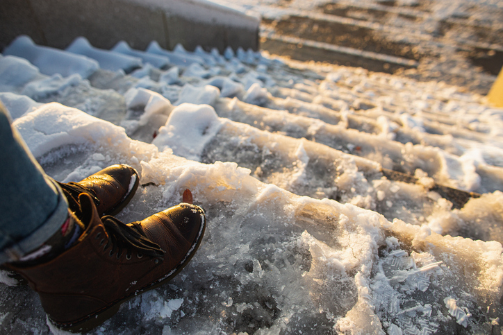 Person standing at the top of an icy staircase - Chicago premises liability lawyer