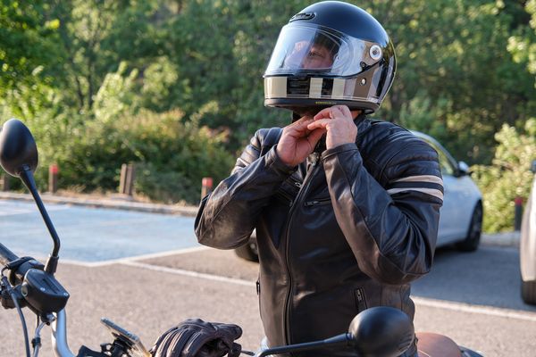Man puts on a motorcycle before going out and riding it. 6 reasons to wear a helmet on a motorcycle