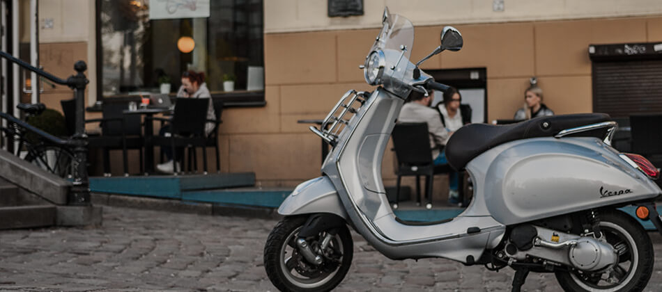 Silver moped parked on road