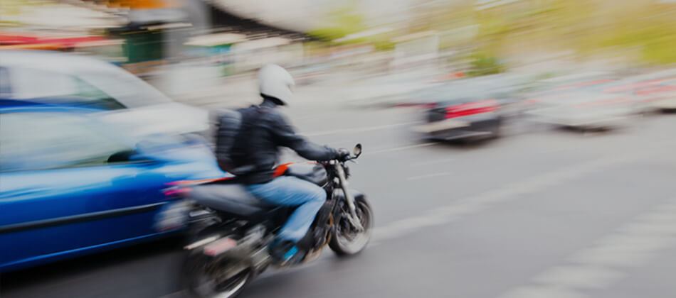 Motorcyclist lane-splitting on city road