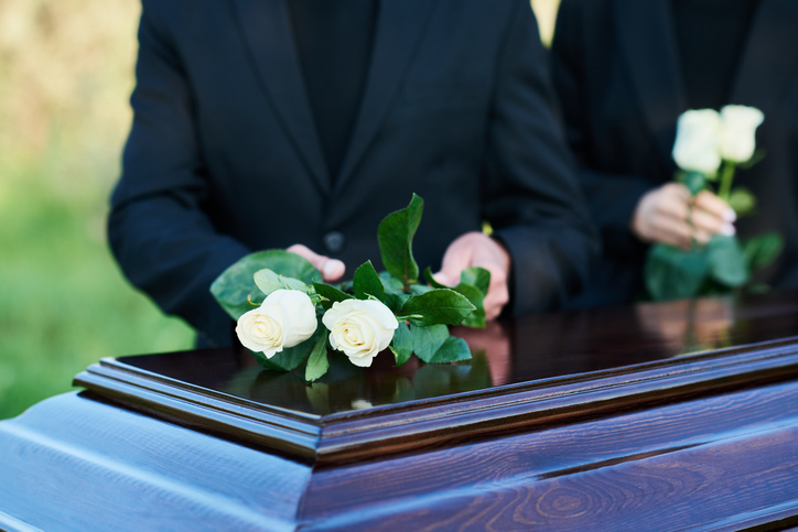 Joliet wrongful death attorney - white roses on coffin lid during funeral