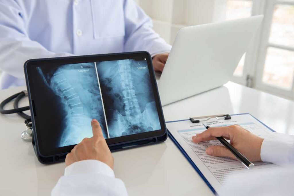 Chicago spinal cord injury lawyers - lumbar vertebrae x-ray image by mri on digital tablet screen with medical team for consult.
