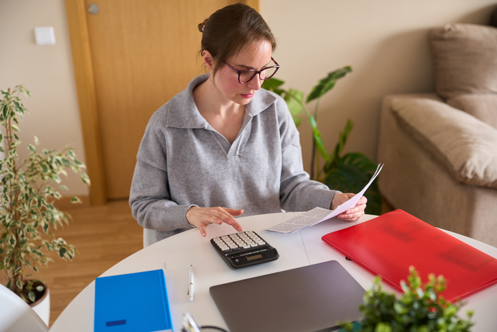 woman looking at paycheck and calculating expenses - does workers' comp pay full salary?