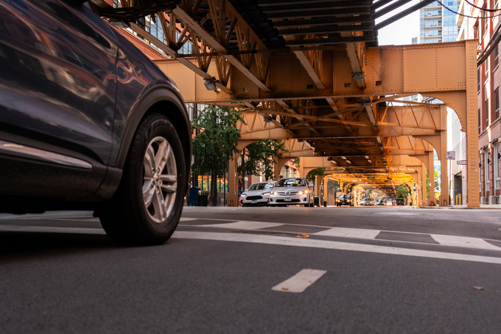 Chicago car accident attorney - downtown Chicago intersection with car and crosswalk under el tracks