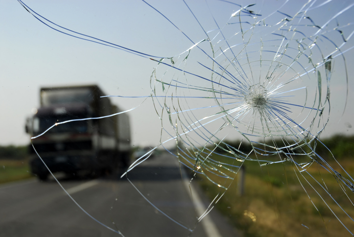 View of broken windshield and truck on a highway - Third-party liability in truck accidents