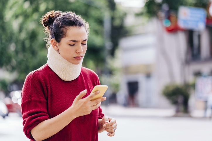 Injured woman using her phone - Why is causation so difficult to prove in personal injury?